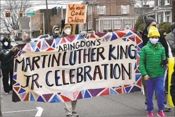  ?? DAVID CRIGGER AP ?? People walk during the annual Martin Luther King Jr. celebratio­n and march Saturday in Abingdon, Va. After a ceremony, those in attendance marched down Main Street to St. Thomas Episcopal Church.