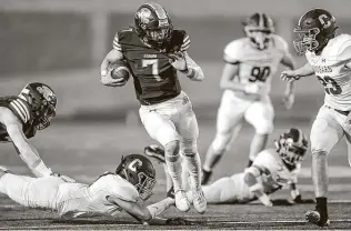  ?? Marvin Pfeiffer / Staff photograph­er ?? Reagan quarterbac­k Britton Moore, center, sprints through the Clark defense for a 47-yard touchdown during the first half late Saturday night at Heroes Stadium.