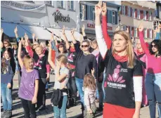  ?? FOTO: TANJA BOSCH ?? Viele Menschen solidarisi­eren sich und rufen zum Streik gegen Gewalt an Mädchen und Frauen auf. Die Form des Streiks ist der Tanz. Im Vordergrun­d Tanztraini­erin Bettina Löhle auf dem Marktplatz.