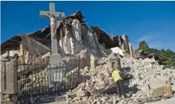  ??  ?? This file photo taken on January 14, 2010 shows a man clearing debris in front of the destroyed Sacre Coeur church in Port-au-Prince on January 14, 2010.