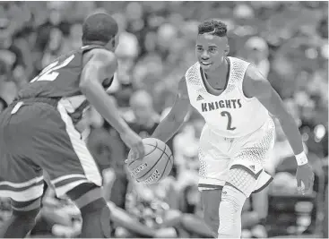  ?? Jerry Baker ?? Elkins guard Ken Busby, right, sizes up Fort Worth Dunbar’s Tobias Phillips during the Class 5A semifinals Thursday night at the Alamodome. Busby topped six Knights in double figures with 21 points.