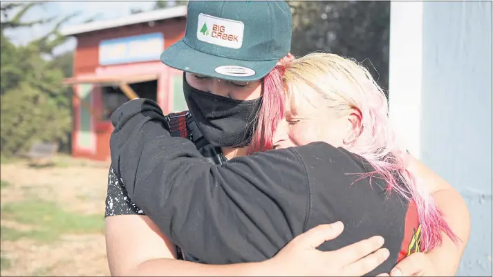  ?? SHAE HAMMOND — STAFF PHOTOGRAPH­ER ?? Kaya Conrad, left, and Brenda Deckman embrace at the Homeless Garden Project in Santa Cruz. They are trainees who work the land and grow crops on a 3.5-acre farm while they get counseling and other services to improve their lives.