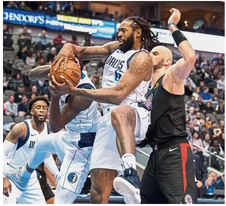  ??  ?? In the fray: Dallas Mavericks center DeAndre Jordan (No. 6) grabs a rebound in front of LA Clippers centre Marcin Gortat (right) in their NBA game at the American Airlines Centre on Sunday. — Reuters