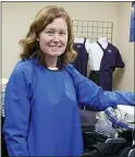  ?? JIM MONE - THE ASSOCIATED PRESS ?? Ann Quigley poses Tuesday, Dec. 15, in a waterproof gown intended for milking cows made by Udder Tech Inc., a Rosemount, Minnesota-based dairy supply company. Minnesota bought 2,300 waterproof gowns intended for milking cows from Udder Tech Inc. The special gowns cost about $46 each when freight was included.