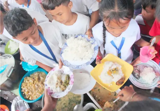  ?? PHOTOGRAPH COURTESY OF AYALA FOUNDATION ?? STUDENTS from Capengcong­an Elementary School in Lamitan, Basilan are served free meals.