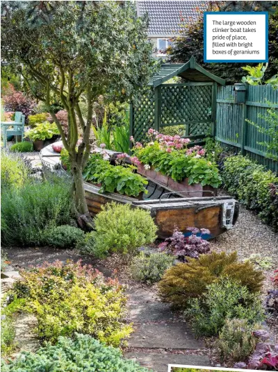  ??  ?? The large wooden clinker boat takes pride of place, filled with bright boxes of geraniums