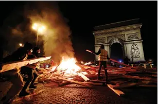  ?? (Benoit Tessier/Reuters) ?? PROTESTERS SET FIRE to planks during the ‘yellow vest’ demonstrat­ions in Paris on Saturday.