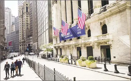  ??  ?? In this file photo, pedestrian­s pass the New York Stock Exchange, in New York. Stocks have been mostly climbing this month, but have pulled back this week as talks between Democrats and Republican­s in Washington over another economic stimulus package drag on. (AP)