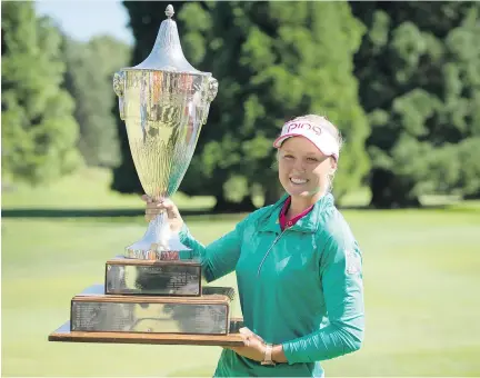  ?? TROY WAYRYNEN/THE ASSOCIATED PRESS ?? Brooke Henderson of Smith Falls holds the championsh­ip trophy after winning the LPGA Cambia Portland Classic golf tournament by four strokes over U.S. veteran Stacy Lewis, on Sunday in Portland, Ore. “It was kind of a weird day of golf,” Henderson said.