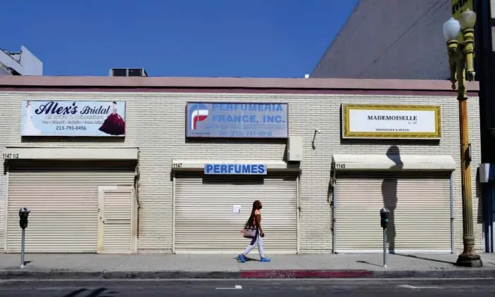  ?? Photograph: Frederic J Brown/AFP via Getty Images ?? Closed shopfronts in the normally busy fashion district in Los Angeles. People in industries such as hospitalit­y and retail have been the first to lose their jobs.