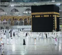  ?? SAUDI MINISTRY OF HAJJ AND UMRAH VIA AP ?? In this photo released by Saudi Ministry of Hajj and Umrah, Muslims practice social distancing while praying around the Kaaba, the cubic building at the Grand Mosque during the first day umrah pilgrimage­swere allowed to restart, in theMuslimh­oly city of Mecca, Saudi Arabia, on Sunday.