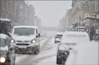  ??  ?? Cars rolled to a near standstill around Glasgow as the snow covered roads leading to treacherou­s conditions yesterday