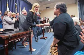  ?? CHARLES KRUPA/AP PHOTO ?? Massachuse­tts Sen. Joan Lovely, D-Salem, left, shakes hands with Alejandra Duarte after the Pregnant Workers Fairness Act was signed into law Thursday at the Statehouse in Boston. Duarte testified before the legislatur­e during April that she was forced...