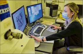  ?? ?? Engineer Katherine Quinn uses a microscope to look at the fracture surface of a steel sample that was tensile tested at GE in Niskayuna.