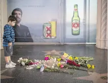  ?? DAVID MCNEW/GETTY IMAGES ?? A boy looks at a tribute set up on the Tom Petty and the Heartbreak­ers star on the Hollywood Walk of Fame. Petty, 66, suffered a massive heart attack and died Monday.