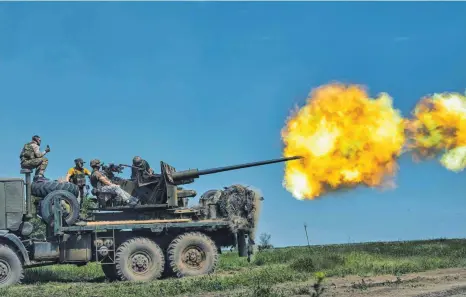  ?? FOTO: LIBKOS/DPA ?? Bachmut ist seit Monaten heftig umkämpft: Ukrainisch­e Soldaten feuern in der Nähe der Stadt eine Kanone auf russische Stellungen ab.