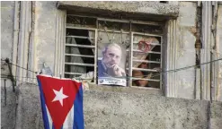  ??  ?? HAVANA: A picture of Fidel Castro and a Cuban flag decorate a home in the Cuban capital yesterday. — AP