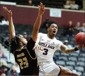  ?? Arkansas Democrat-Gazette/THOMAS METTHE ?? UALR’s Rayjon Tucker (3) lays in a shot over Texas State’s Alex Peacock (23) during the first half of the Trojans’ 67-60 loss Saturday at the Jack Stephens Center in Little Rock. Tucker led UALR with 20 points and six rebounds.