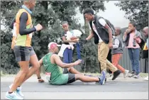  ?? PICTURE: SHELLEY KJONSTAD/AFRICAN NEWS AGENCY (ANA) ?? HELPING HAND: A bystander helps a runner who had stumbled at Harrison Flats.