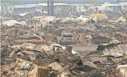  ?? JEFF CHIU/AP ?? A car sits in the middle of property destroyed by fires at Journey's End mobile-home park in Santa Rosa, California.