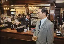  ?? KEVIN HAGEN / AP ?? A wax statue of actor Jon Hamm stands by the bar with a drink at Peter Luger Steakhouse on Friday in New York. The statue, on loan from Madame Tussauds, will help fill out the restaurant during COVID-19 occupancy restrictio­ns.