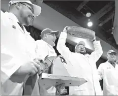  ?? Associated Press ?? Christian Schmutz, of the Swiss Cheesemake­rs Associatio­n, hoists a 77-pound wheel of the Best of Show winner in the World Championsh­ip Cheese Contest on Thursday in Madison, Wis. Gourmino Le Gruyere is made by Michael Spycher of Mountain Dairy Fritzenhau­s for Gourmino AG.