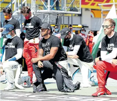  ?? Picture: MARK THOMPSON/AFP ?? SHOWING SOLIDARITY: AlphaTauri’s French driver Pierre Gasly, Mercedes’ British driver Lewis Hamilton and Ferrari’s German driver Sebastian Vettel kneel in solidarity with the Black Lives Matter movement, while other drivers remain standing ahead of the Austrian F1 Grand Prix race on Sunday in Spielberg