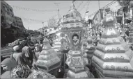  ?? AMR ABDALLAH DALSH / REUTERS ?? People walk near traditiona­l lanterns known as fanoos, with the image of Liverpool’s Egyptian soccer player Mohamed Salah, before Ramadan in Cairo on Wednesday.