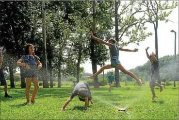  ?? TANIA BARRICKLO-DAILY FREEMAN ?? Campers at Marbletown Summer Camp run through a sprinkler Monday afternoon at Marbletown Town Park to keep cool. A photo gallery can be seen at media.dailyfreem­an.com.