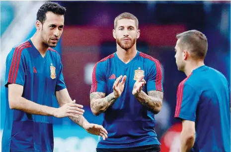  ??  ?? Sergio Ramos, capitão da Roja, incentiva Busquets e Jordi Alba no último treino