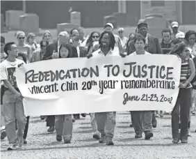  ?? PAUL SANCYA/AP ?? Activists walk to the grave of Vincent Chin during a 20th-anniversar­y memorial for Chin at Forest Lawn Cemetery in Detroit on June 23, 2002.