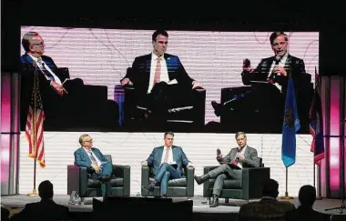  ?? Melissa Phillip/Staff photograph­er ?? Carl Campbell, left, co-founder and COO Alamo Resources, moderates a discussion Wednesday with Oklahoma Gov. J. Kevin Stitt, center, and Wyoming Gov. Mark Gordon, right, during the NAPE Summit.