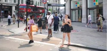  ?? File/ Associated Press ?? ↑
People throng Oxford Circus in London.