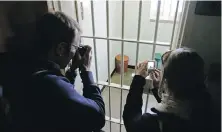  ?? SCHALK VAN ZUYDAM, AP ?? Tourists take photos of former South African president Nelson Mandela's cell on Robben Island, South Africa.