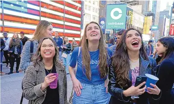  ?? RICHARD DREW/ASSOCIATED PRESS ?? Coinbase employees celebrate Wednesday outside the Nasdaq MarketSite in New York’s Times Square. Wall Street focused on Coinbase Wednesday as the digital currency exchange became a publicly traded company.