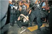  ??  ?? 一名示威者在警方包围­下束手就擒。（美联社照片）