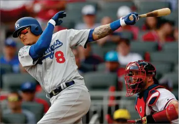  ?? AP PHOTO BY JOHN BAZEMORE ?? Los Angeles Dodgers shortstop Manny Machado (8) hits an RBI single against the Atlanta Bravesduri­ng the first inning in Game 4 of baseball’s National League Division Series, Monday, Oct. 8, in Atlanta. Los Angeles Dodgers’ Max Muncy scored on the play.