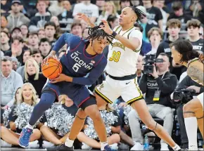  ?? MARK STOCKWELL/ AP PHOTO ?? UConn guard Stephon Castle, left, protects the ball from Providence forward Rafael Castro during a game Saturday in Providence, R.I.