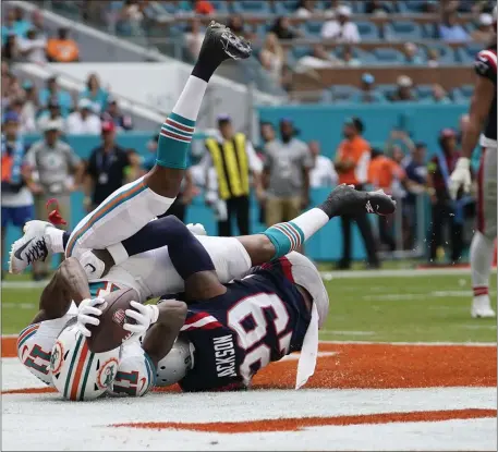  ?? LYNNE SLADKY — THE ASSOCIATED PRESS ?? Miami Dolphins wide receiver Cedrick Wilson Jr. (11) scores a touchdown under pressure from New England Patriots cornerback J.C. Jackson (29) during the first half of an NFL football game, Sunday, Oct. 29, 2023, in Miami Gardens, Fla.