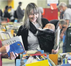  ?? PHOTO: CHRISTINE O’CONNOR ?? All booked out . . . Bryony Harrison and son Aurelius Yates, of Dunedin, search for bedtime reading at the Dunedin Public Libraries book sale.