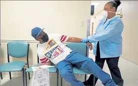  ?? ROGELIO V. SOLIS / AP ?? Wilbert Marshall, 71, left, pretends to be scared of receiving the COVID-19 vaccine from a nurse Wednesday at the Aaron E. Henry Community Health Service Center in Clarksdale, Miss.