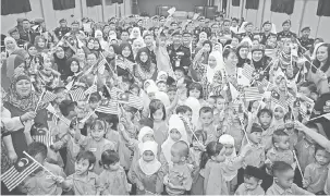  ??  ?? KENANGAN: Sallehuddi­n bergambar kenangan bersama kanak-kanak dan ibu bapa serta warga PPM Wilayah 5 Sarawak semasa Program Moh Ngeteh Merdeka sempena Sambutan Hari Polis Marin Ke-70 di Kuching semalam.