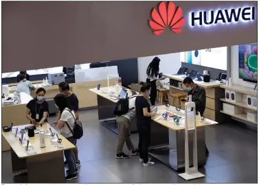  ?? (AP/Ng Han Guan) ?? Shoppers look at Huawei’s latest products Wednesday at a store in Beijing. Under the U.K.’s ban, all Huawei-made equipment that’s already installed for 5G networks will have to be removed by 2027. Video is available at arkansason­line.com/716uk/.