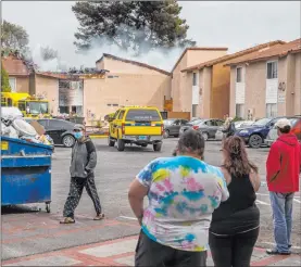  ?? Las Vegas Review-journal @Left_eye_images ?? L.E. Baskow Residents look on as Clark County and Las Vegas Fire Department firefighte­rs work to extinguish a blaze Tuesday at the Twain Estates Apartments.