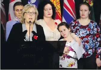  ?? SEAN KILPATRICK, THE CANADIAN PRESS ?? Elizabeth May, leader of the federal Green Party, calls on the federal government on Tuesday to urgently intervene in the case of Dr. Elena Musikhina, centre. Musikhina is holding her granddaugh­ter, Iaroslava Sunatori, 8.