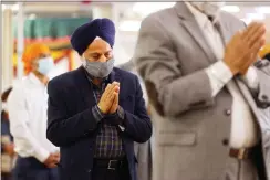  ?? Ap-jason Decrow ?? Sikhs pray during Vaisakhi celebratio­ns at Guru Nanak Darbar of Long Island, on April 13, in Hicksville, N.Y. Sikhs across the United States are holding toned-down Vaisakhi celebratio­ns this week, joining people of other faiths in observing major holidays cautiously this spring as COVID-19 keeps an uneven hold on the country.