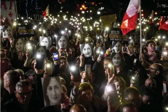  ?? — AFP photo ?? People holding placards and photos of killed journalist Daphne Caruana Galizia stage a protest called by Galizia’s family and civic movements outside the office of the prime minister in Valletta.