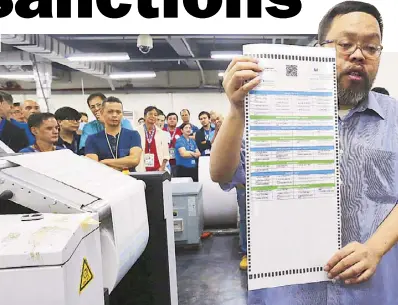  ?? BOY SANTOS ?? Commission on Elections spokesman James Jimenez holds up a sample ballot during the start of printing of ballots for the May 13 polls at the National Printing Office in Quezon City yesterday.