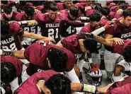  ?? Sam Owens/Staff photograph­er ?? The Uvalde Coyotes kneel in the locker room before playing Eagle Pass Winn on Friday in Uvalde.