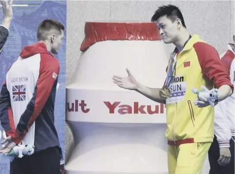  ??  ?? 0 China’s 200m freestyle gold medallist Sun Yang gestures at Duncan Scott after the Scot refused to share the podium with him.